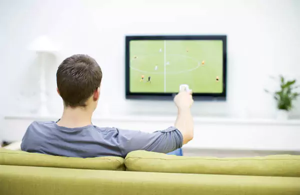 A Man Watching Sports on Television